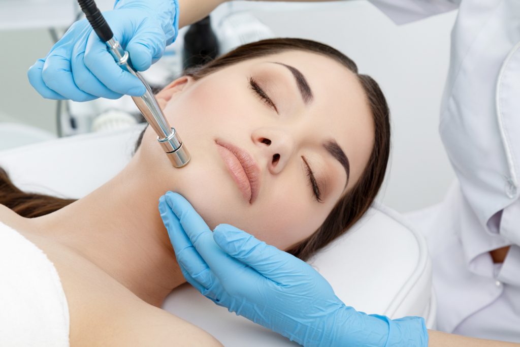 A woman undergoing a microdermabrasion procedure at a spa