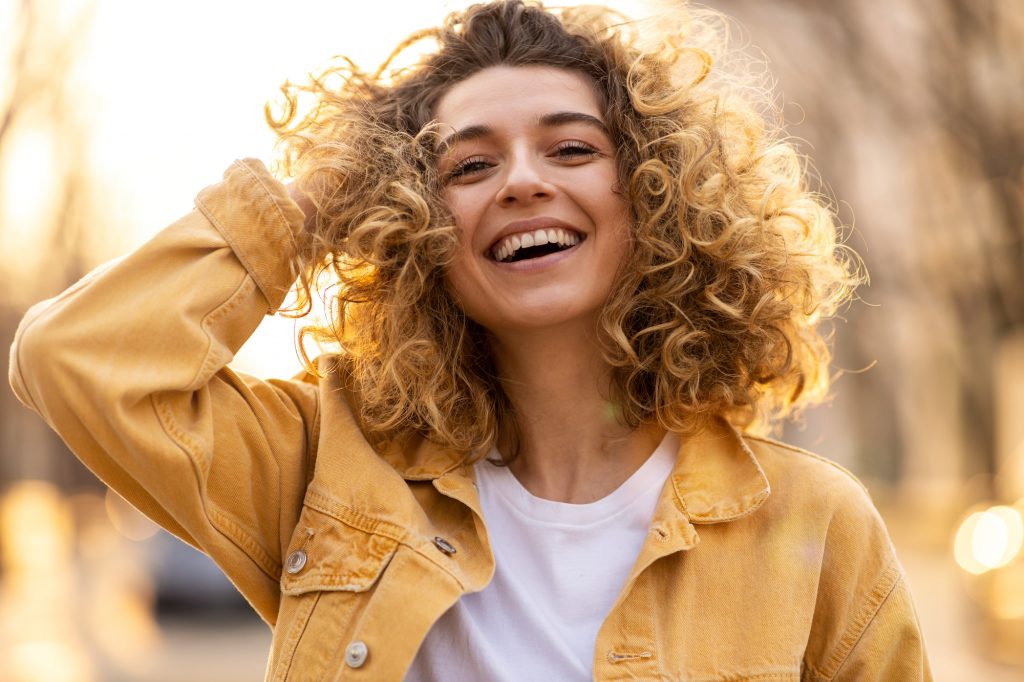 Young woman with curly hair smiling 