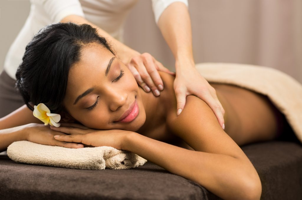 A young woman undergoing a massage treatment at a spa